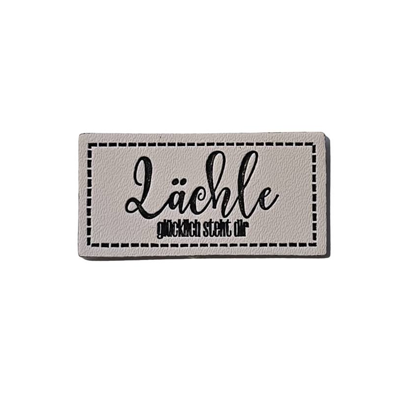 [629 3447 000] "Lächle - glücklich steht dir" Kunstleder Label 4 x 2 cm
